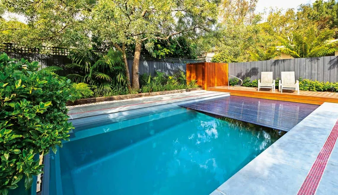 Leisure Pools Front Range creates a relaxing backyard spot with a modern pool, comfy chairs, and private fenced space.